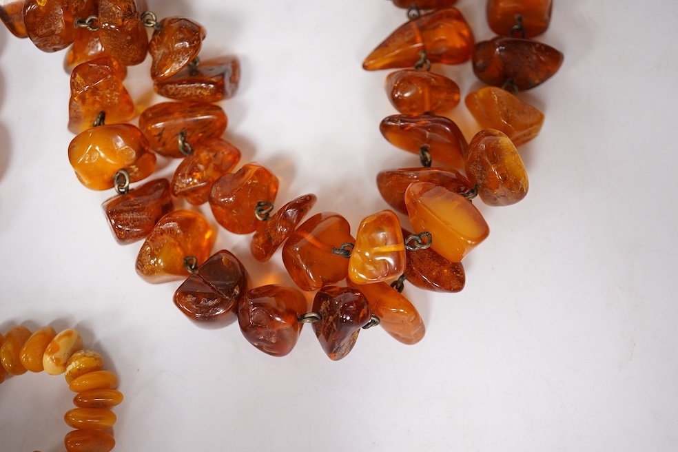 Three assorted amber necklaces including a single strand graduated oval bead necklace, 40cm, gross weight 37 grams, the other two necklaces gross weight 240 grams. Condition - poor to fair